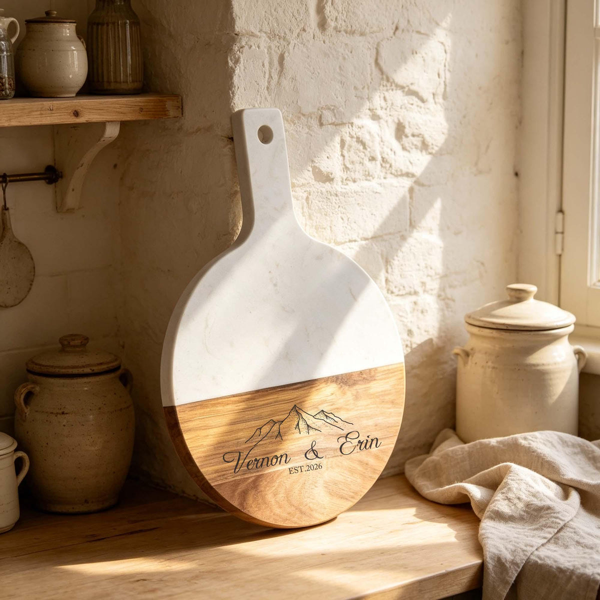 Personalised Round Marble & Acacia Serving Board: round marble and acacia board engraved with two names and a mountain design