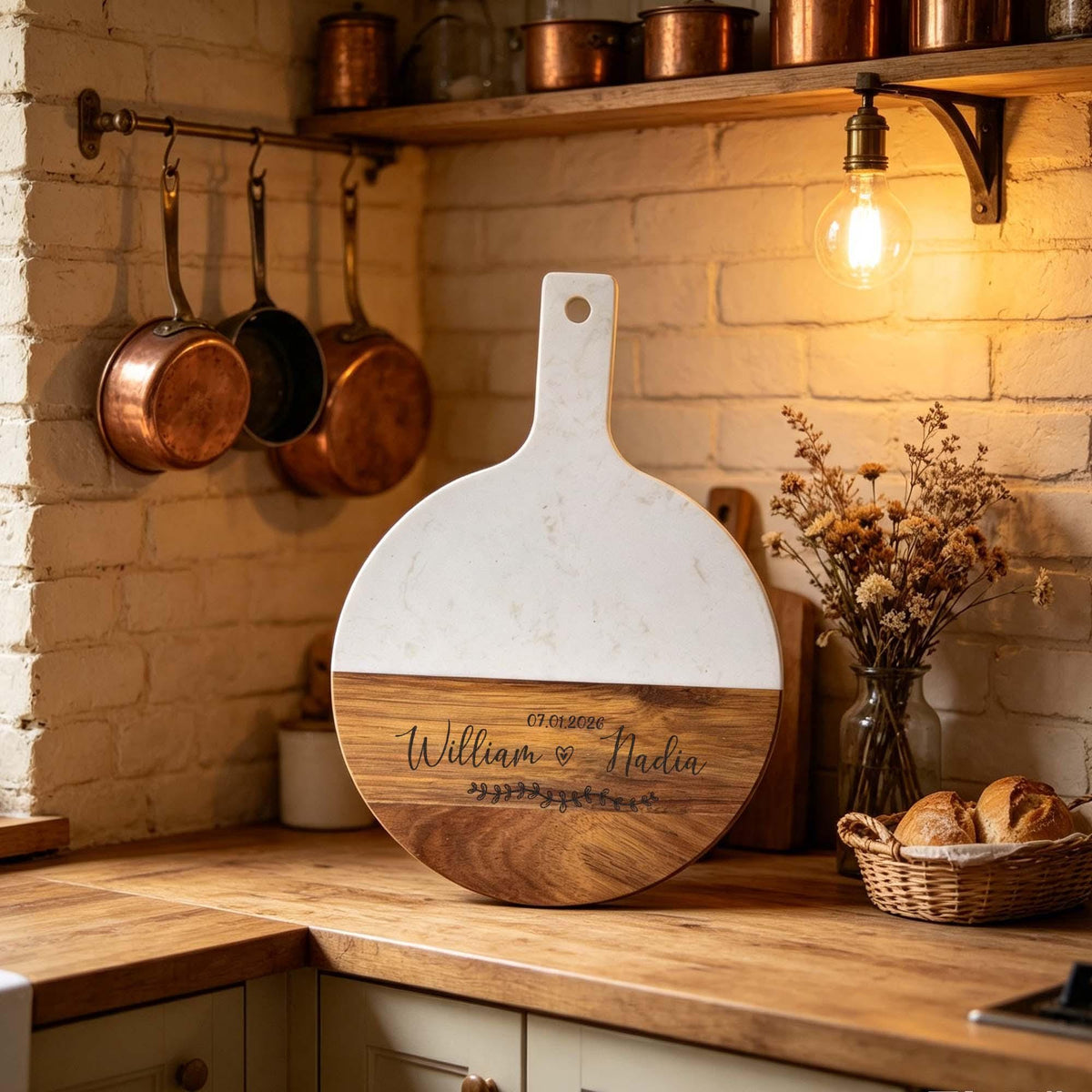 Personalised Round Marble & Acacia Serving Board: round marble board engraved with names, beside copper pans